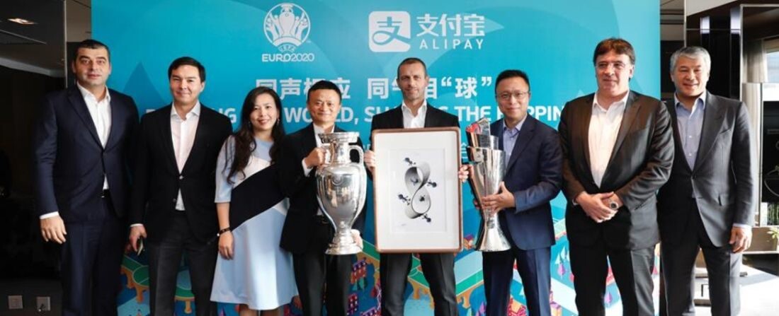 Alexander Ceferin, az UEFA főtitkára (középen) és Jack Ma (tőle balra), az Alibaba alapítója a BL serleggel, miután bejelentették, hogy az UEFA 8 éves szerződést kötött az Alipay-jel.